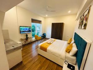 a bedroom with a bed and a desk and a television at Amahi Inn in Gurgaon