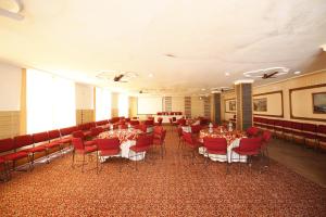 a banquet hall with red chairs and tables in a room at Vardaan Hotels - PatniTop in Patnitop