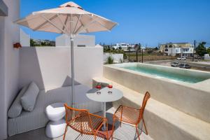 a patio with a table and chairs and an umbrella at Viva Nove Suites in Kamari +33 photos