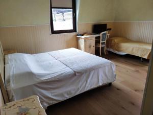 a bedroom with two beds and a desk and a window at Hotel Atlanta Augustus in Venice-Lido