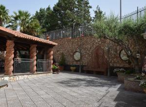 a patio with a stone wall and a bench at Victoria House in Mascalucia