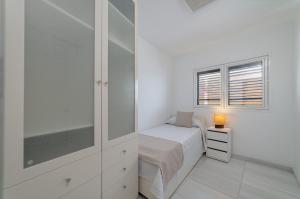 プラヤ・ブランカにあるApartamento 1 linea centro Playa Blancaの白いベッドルーム(ベッド1台、窓付)