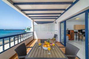 una mesa en un balcón con vistas al océano en Apartamento 1 linea centro Playa Blanca, en Playa Blanca