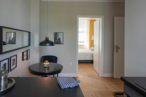 a living room with a table and a bedroom at Pssst ! Geheimtip in Rüttenscheid in Essen