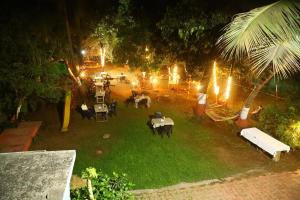eine Aussicht über den Garten in der Nacht mit Tischen und Stühlen in der Unterkunft Visava Cottages Kihim Beach in Kīhīm