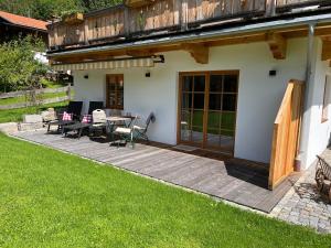 a patio with a table and chairs and a balcony at Ferienwohnung Sunnseitn in Bayrischzell