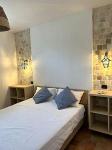 モンテ・ディ・プローチダにあるLa Lantanaのベッドルーム1室(青い枕2つ付きのベッド1台付)