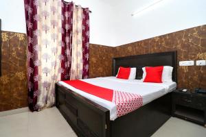 een kleine slaapkamer met een bed met rode kussens bij OYO Flagship 18943 Hotel Punjab Residency in Banūr