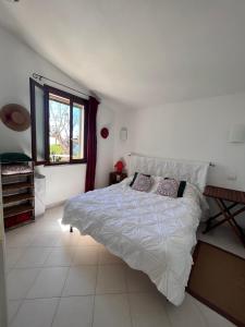 a bedroom with a large white bed and a window at Villa Elicis in Pinus Village