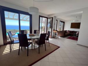 a dining room and living room with a table and chairs at Villa Elicis in Pinus Village
