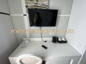 een badkamer met een toilet en een tv aan de muur bij PORTOFINO SUITE VISTA MARE CON SPIAGGIA PRIVATA in Portofino