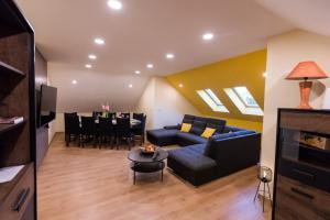 a living room with a blue couch and a table at Klečka vila (apartment) with Hot tub & Sauna in Ogulin