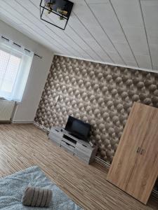 uma sala de estar com uma parede com uma televisão em Ferienwohnung/Monteurunterkunft Leopolshall em Staßfurt