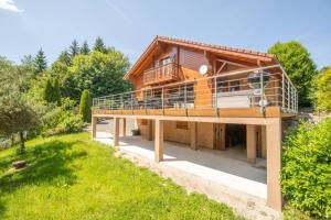 ein Haus mit einer großen Terrasse darüber in der Unterkunft Le Chant du Ruisseau SPA - Sauna in Le Tholy