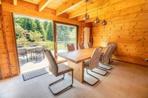 a wooden dining room with a table and chairs at Le Chant du Ruisseau SPA - Sauna in Le Tholy