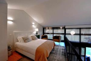 a bedroom with a large bed and a balcony at Casas do Ermo Ermo Villas in Fafe