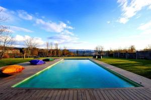 a swimming pool in a backyard with a wooden deck at Casas do Ermo Ermo Villas in Fafe