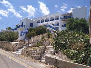 a building with blue and white buildings on the side of a road at Corali Hotel in Piso Livadi