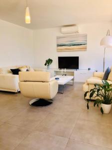 a living room with couches and a flat screen tv at Siriana Suites 101, 001 in Benalmádena