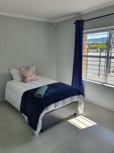 Bett in einem Zimmer mit einem Fenster und einem Bett sidx sidx sidx sidx in der Unterkunft Stellenbosch Idasvalley Gem in Stellenbosch