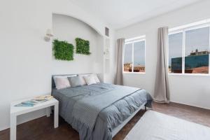 1 dormitorio con cama, mesa y ventanas en Modern, contemporary flat-15 minutes to Venice, en Mestre