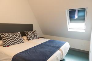 a bedroom with a bed with two pillows and a window at RK Farallón Canteras in Las Palmas de Gran Canaria