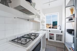 cocina blanca con fogones y fregadero en Modern, contemporary flat-15 minutes to Venice, en Mestre