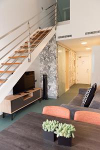 a living room with a couch and a tv and stairs at RK Farallón Canteras in Las Palmas de Gran Canaria