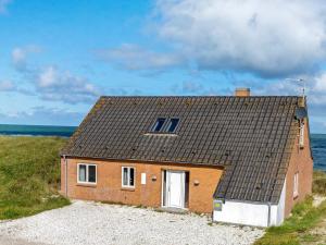 una pequeña casa de ladrillo al lado de una playa en 10 person holiday home in Fr strup, en Lild Strand