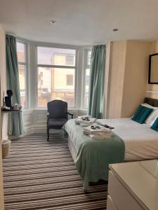 ein Hotelzimmer mit 2 Betten und einem Stuhl in der Unterkunft The Oxfordshire in Blackpool