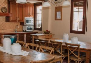 a kitchen with a wooden table and chairs and a kitchen with at Entrada Río Lobos in Hontoria del Pinar