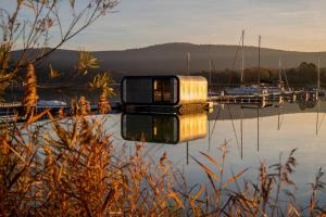 a house sitting on top of a body of water at Modul Kometa in Hrdoňov