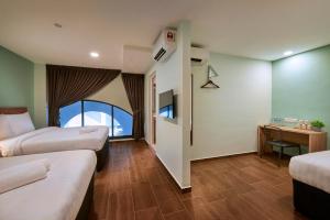 a hotel room with two beds and a desk at ZONE Hotels, Eco Grandeur in Bandar Puncak Alam