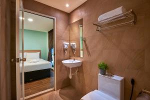 ein Bad mit einem Waschbecken, einem WC und einem Bett in der Unterkunft ZONE Hotels, Eco Grandeur in Bandar Puncak Alam