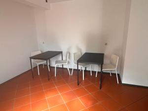 un comedor con 2 mesas y sillas blancas en Monteurzimmer Linz, en Linz