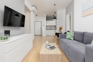 a living room with a couch and a tv at Wola Pet-friendly Apartments with AC Sławińska by Renters in Warsaw