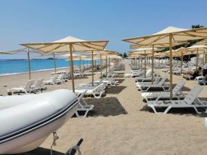 una fila de sillas y sombrillas en una playa en Villa tipindeki 3+1 en Alanya