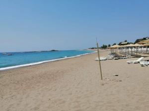a pole on a beach with chairs and umbrellas at Villa tipindeki 3+1 in Alanya