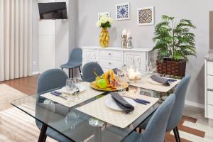 una sala da pranzo con tavolo e sedie in vetro di Libertà Lodge Apartment - Minho's Guest a Braga