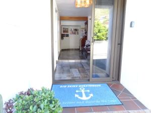 una alfombra de bienvenida en la puerta principal de una casa en Big Skies Guesthouse en Gordonʼs Bay