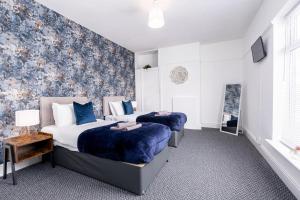 two beds in a room with a wall mural at Stylish Home with Garden, Free Street Parking in Hull
