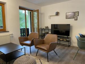 een woonkamer met stoelen en een flatscreen-tv bij moderne Ferienwohnung mit Berg- und Isarblick in Mittenwald