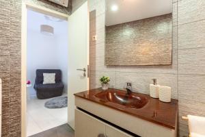 La salle de bains est pourvue d'un lavabo brun et d'une chaise. dans l'établissement Apartamento Íris - Minho's Guest, à Braga