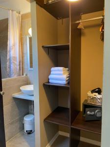 La salle de bains est pourvue d'un placard, de serviettes et d'un lavabo. dans l'établissement Boutique Centrale, à Brione sopra Minusio