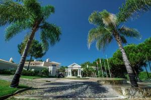 una casa con palmeras delante en Sera - Luxury 3 bedroom apartment with pool, golf,beach, en Ludo