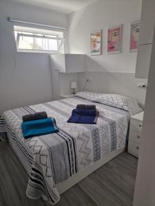 una camera da letto con un grande letto con cuscini blu di Chalet con 3 camere e giardino a Maspalomas