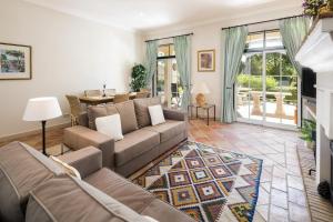 een woonkamer met een bank en een tafel bij Sera - Luxury 3 bedroom apartment with pool, golf,beach in Ludo