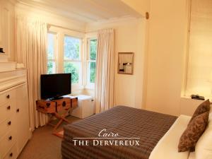 a bedroom with a bed and a television and a window at The Devereux Boutique Hotel in Auckland
