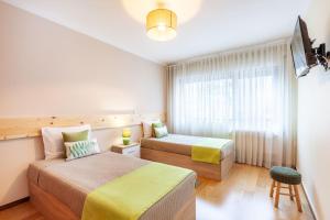 um quarto de hotel com duas camas e uma janela em Apartamento Hibiscos - Minho's Guest em Braga