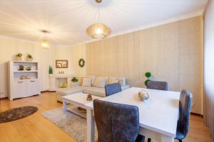 uma sala de estar com uma mesa e um sofá em Apartamento Hibiscos - Minho's Guest em Braga